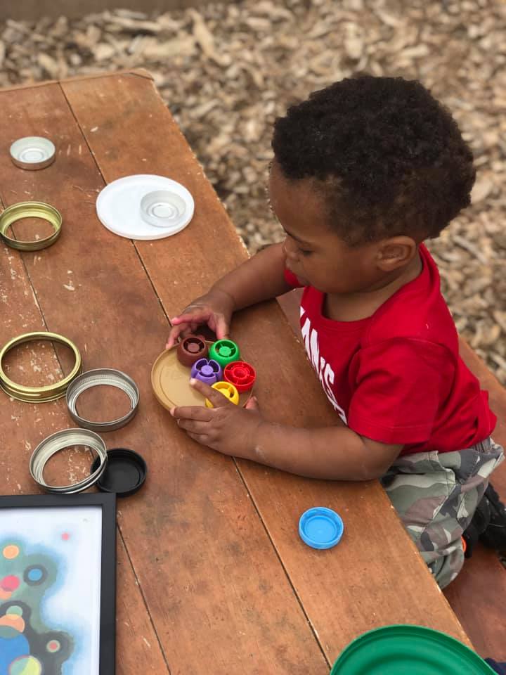 Child doing artwork out of recycled materials, glue, washable paints